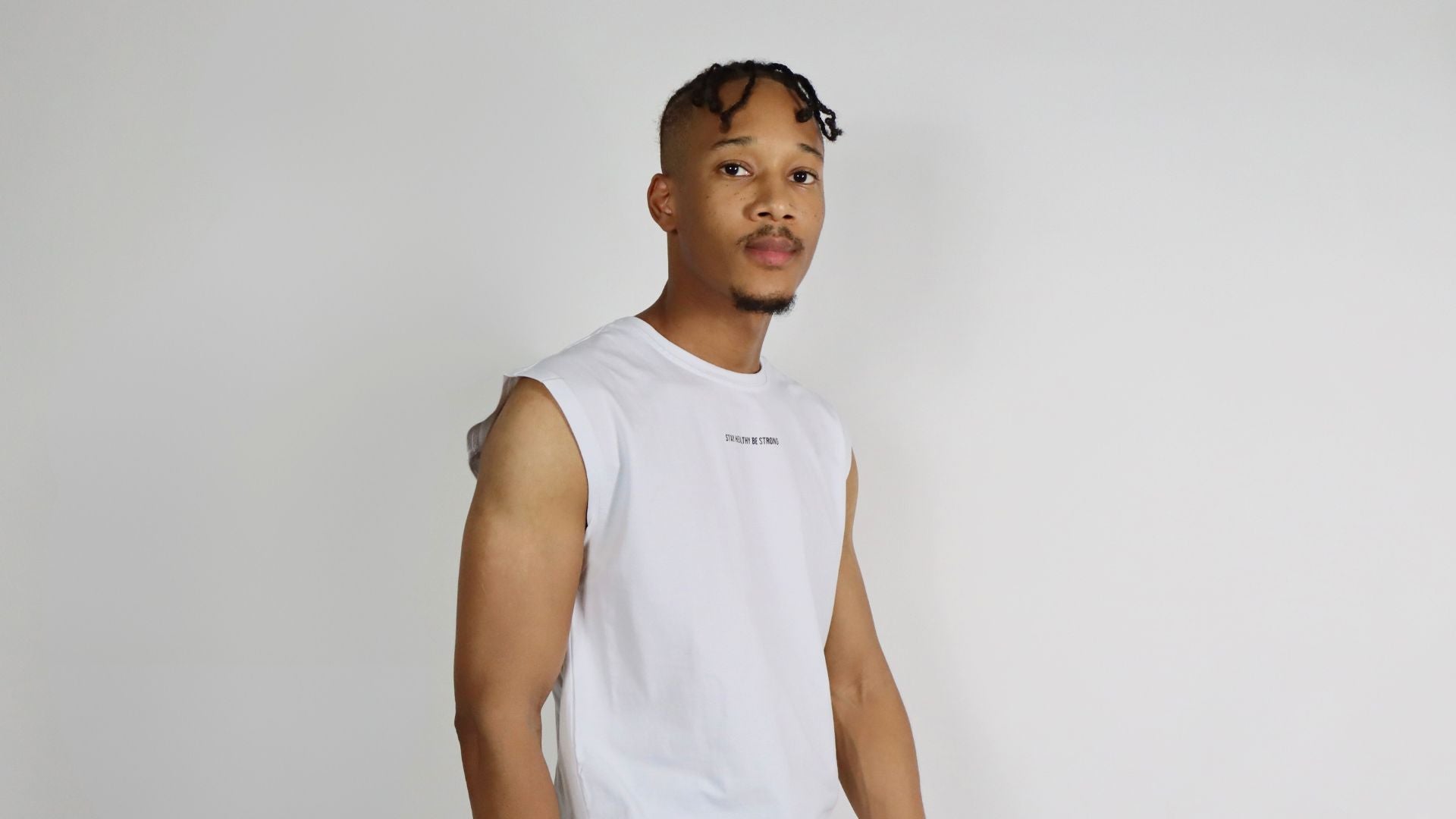 headshot of a male wearing a white tank top
