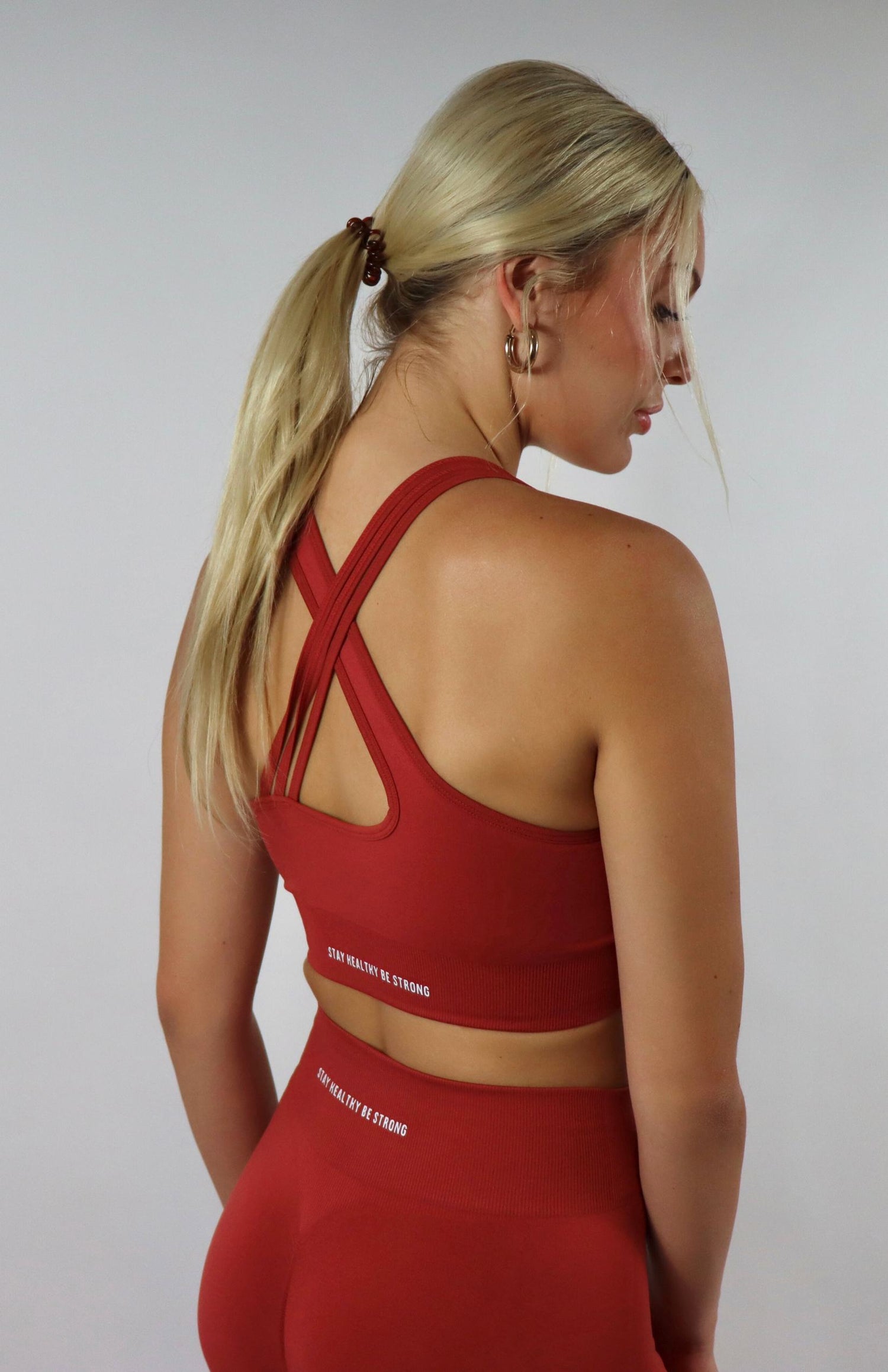 Red cross back sports bra with red  high waisted scrunch leggings with black cross back sports bra