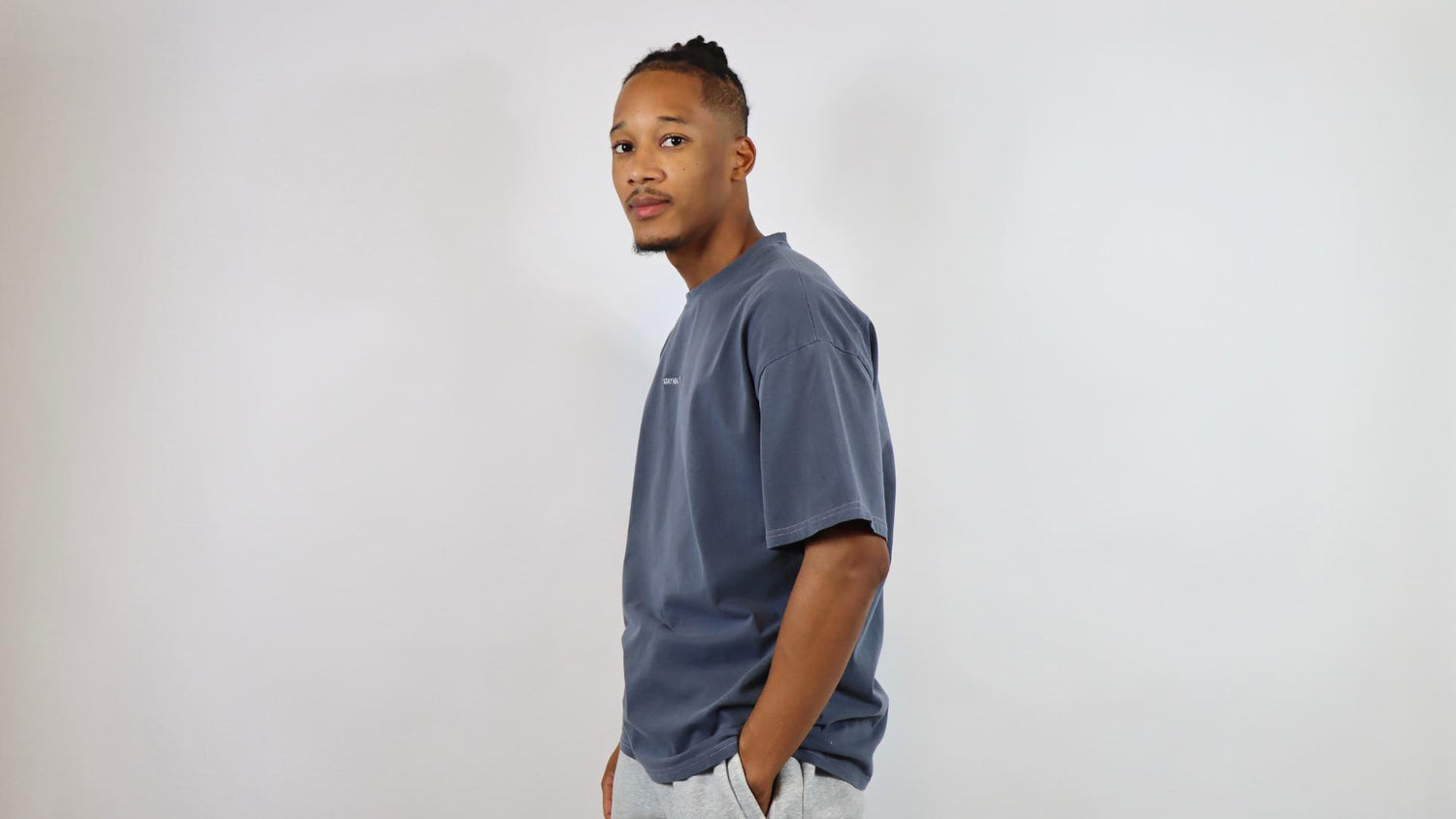 a male wearing a blue oversized t-shirt