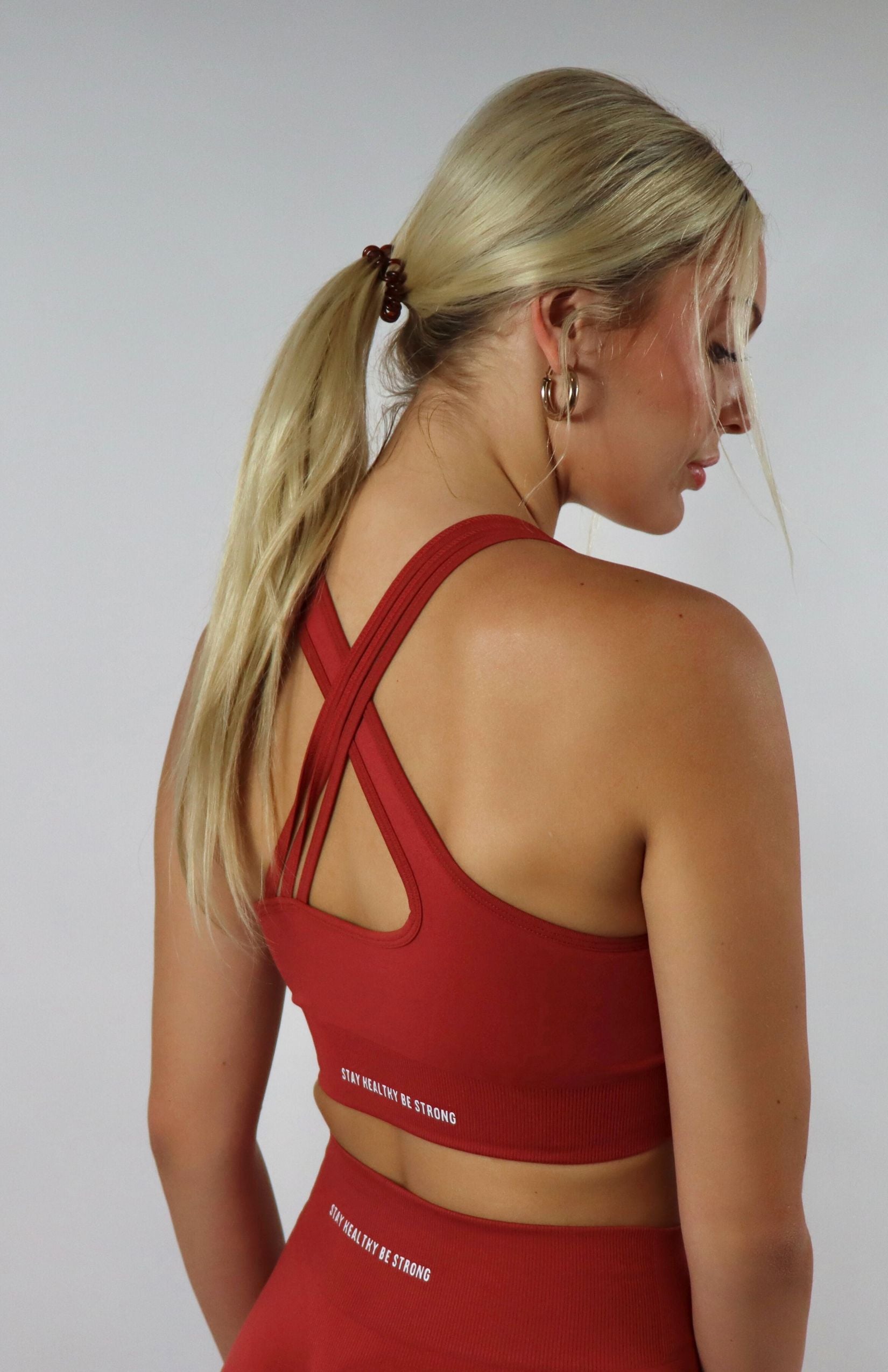 Red cross back sports bra with red  high waisted scrunch leggings with black cross back sports bra 